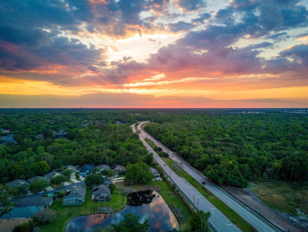 Drone view of sunset over a highway by mdburnette is licensed under CC-CC0 1.0